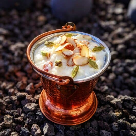 Creamy, sweet, kheer (rice pudding) cooked with whole milk, sugar, cardamom, topped with sliced almonds.